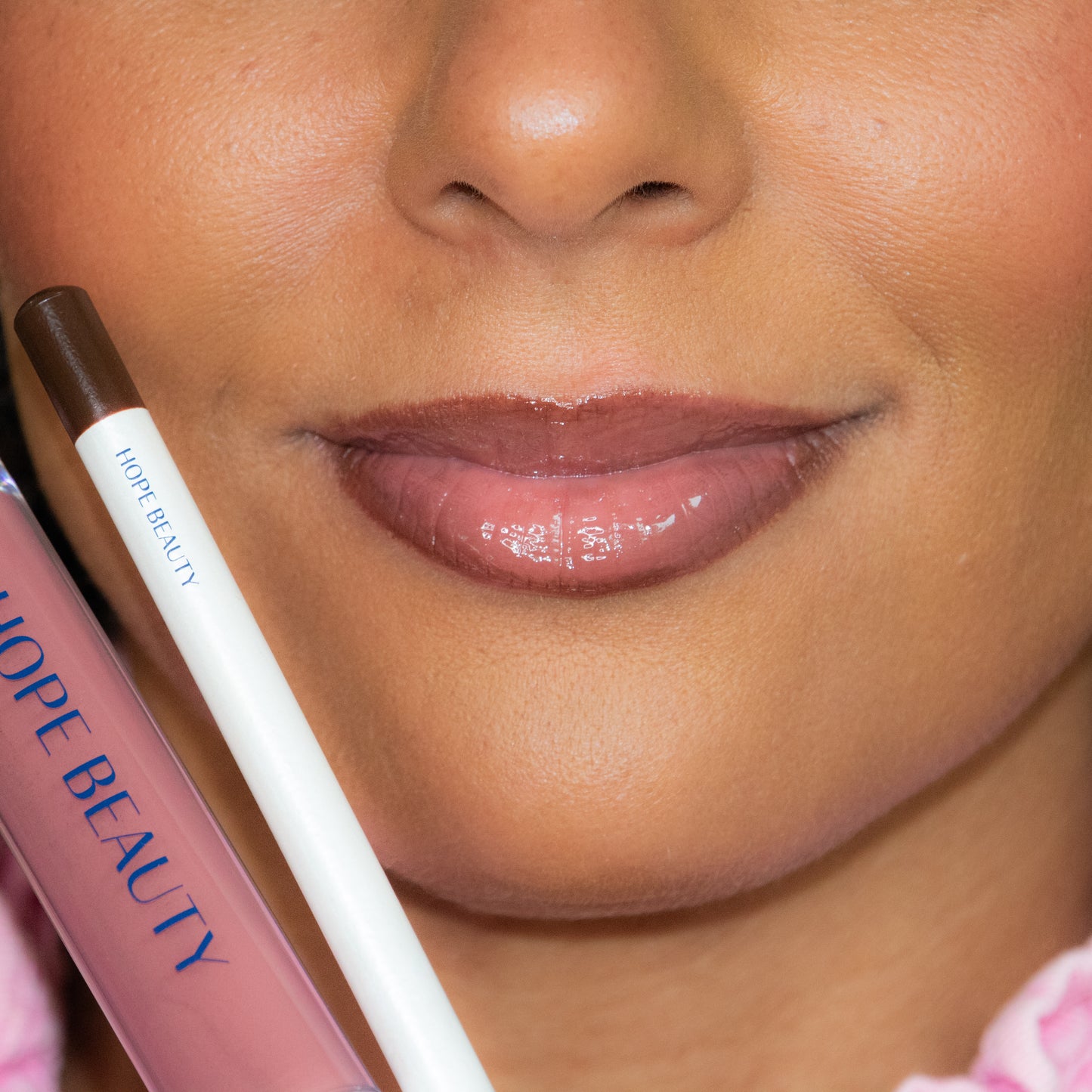Deep skinned model wearing Hope Beauty Esther Lip Kit, a lip gloss and lip liner set inspired by Queen Esther. Biblically inspired cosmetics. Faith inspired cosmetics. Inspirational makeup. Christian makeup. Women of the Bible. Lip oil and lip gloss hybrid.